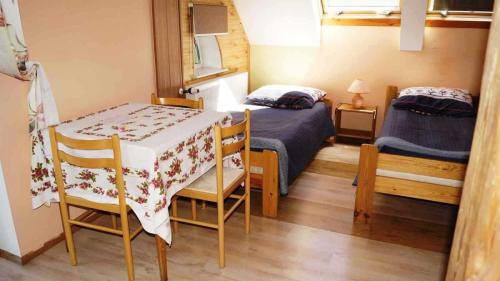 Pokój brzoskwiniowy - widok stołu z krzesłami i dwa łóżka